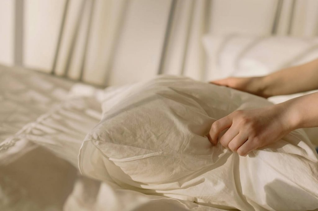 Personne qui refait le lit pour le service de gestion du linge de notre conciergerie à Boulogne.